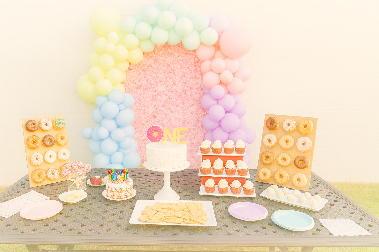 One year old birthday setup with cake, donuts, and cupcakes